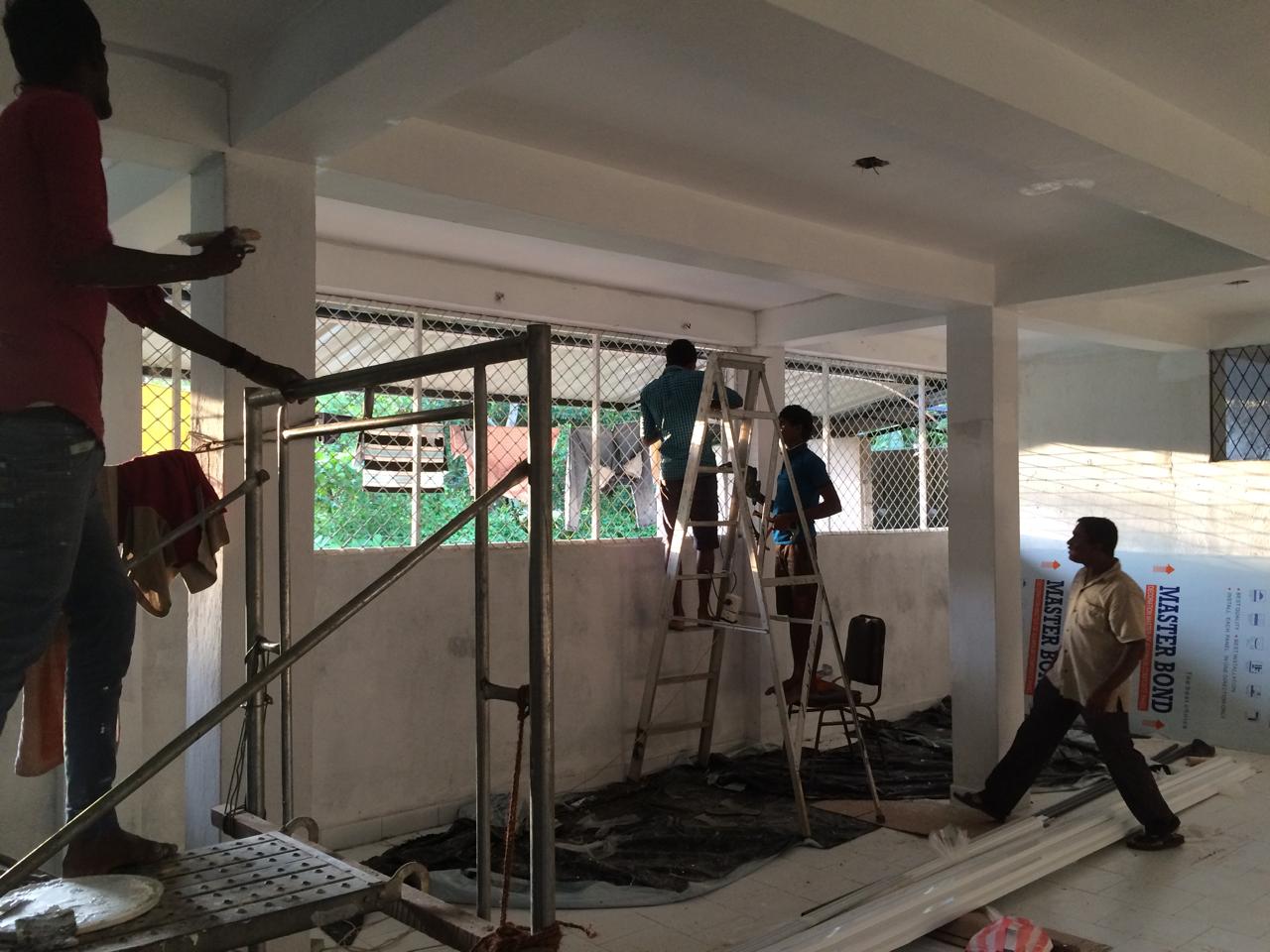 Workers installing walls and windows during interior construction