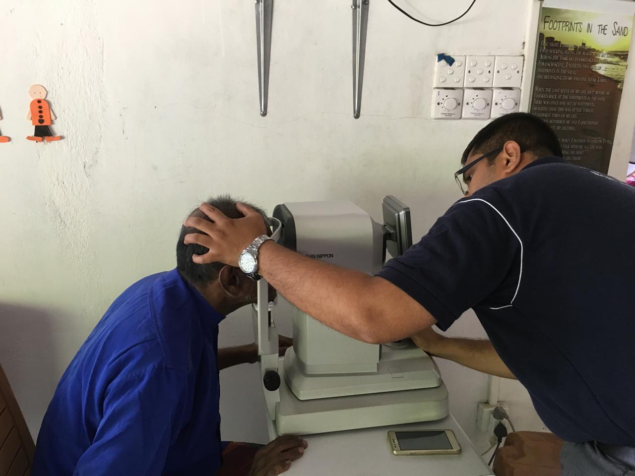 Vision Care professional examining an elderly resident's eyes